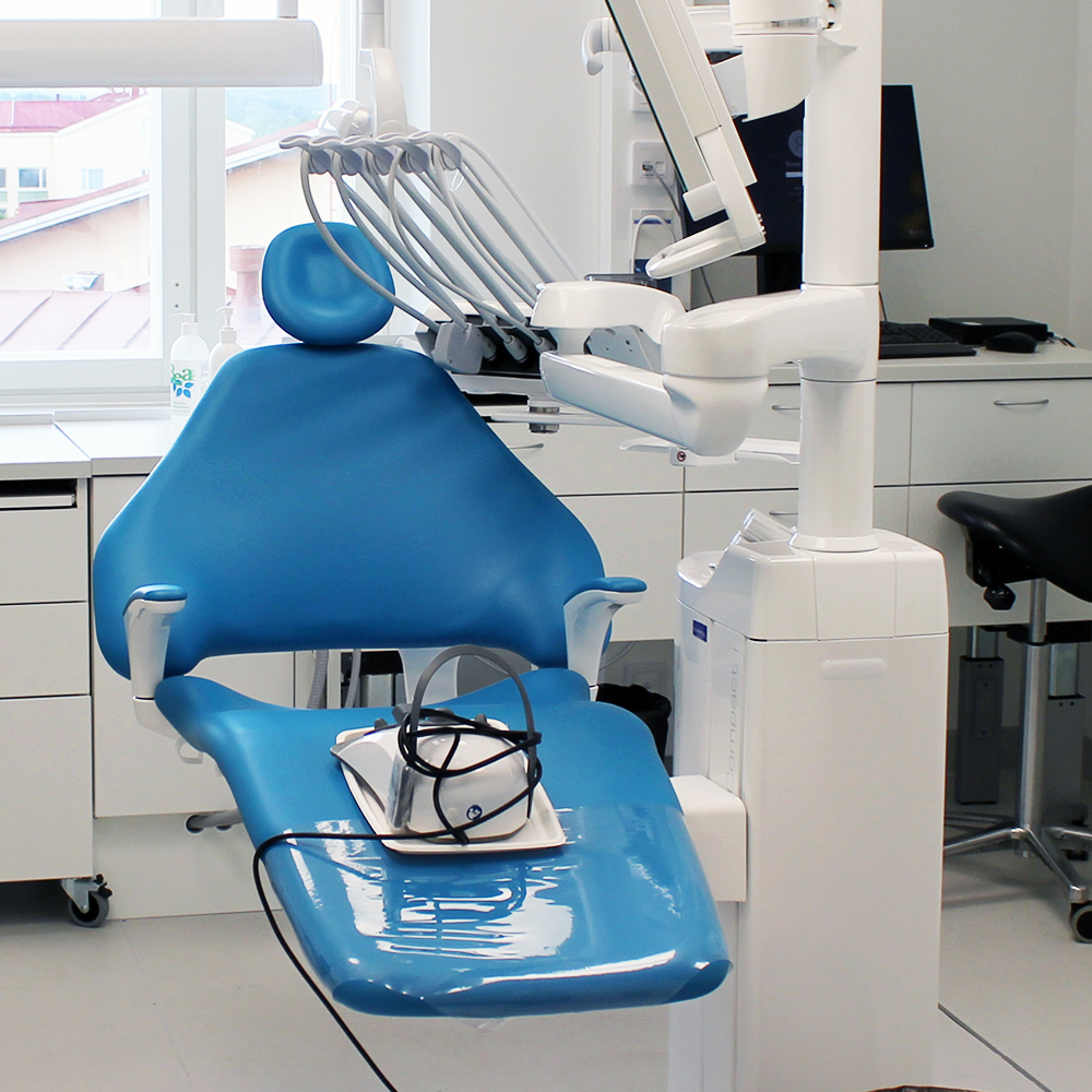 Valokuvassa hammashoitoon tarkoitettu sinisellä tekonahkalla päällystetty hoitotuoli. Tuoli sijaitsee hammashoidon hoitohuoneessa.