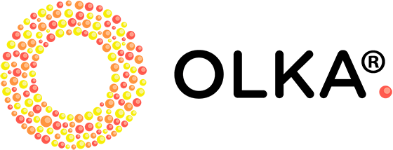 OLKA-toiminnan logo, jossa keltaisista, oransseista ja punaisista pienistä palloista muodostuu  rinkelimäinen pyörylä, jossa keskusta valkoinen. Oikealla lukee mustin suuraakkosin OLKA-sana. 